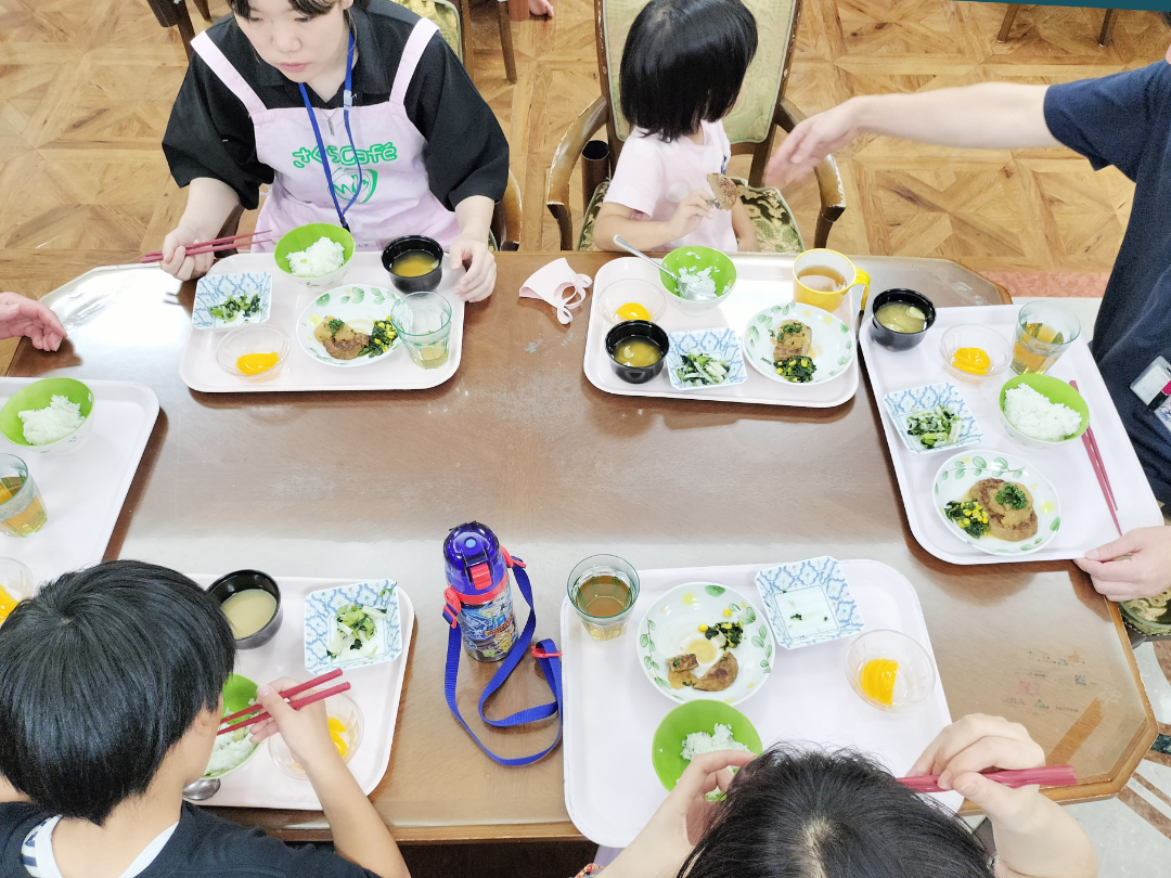 ボランティアの方と子供たちで食事ととっている写真