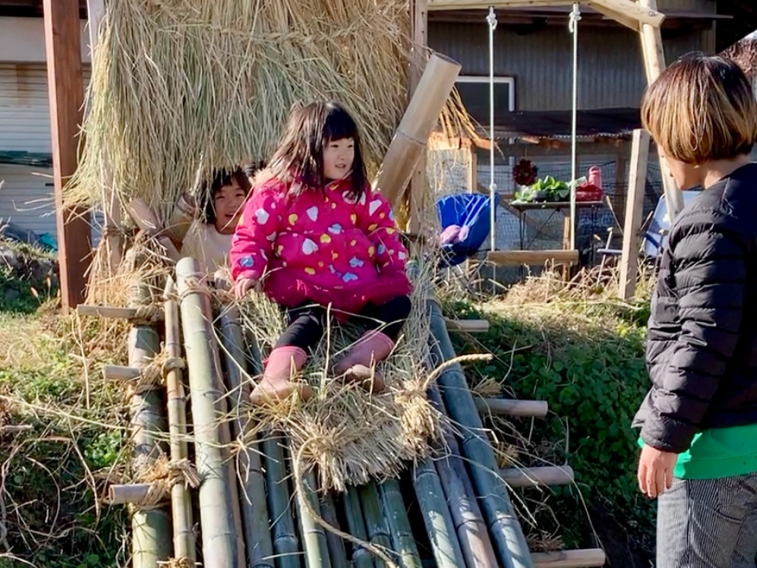 手作りの竹で作った滑り台で遊ぶ子供の画像