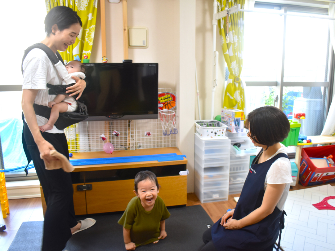 ヘルパーとお母さんが子供を見守っている写真