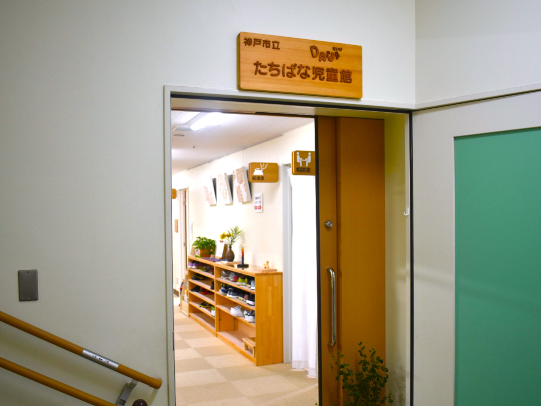 たちばな児童館の入り口の写真。木製の看板が扉上に設置されている