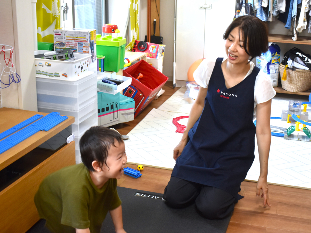 笑顔でコミュニケーションをとる子供とヘルパーの写真