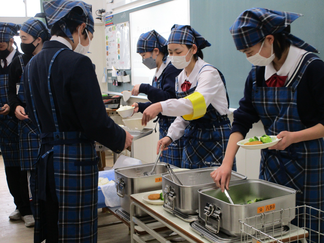 学生が給食を配膳している様子の写真